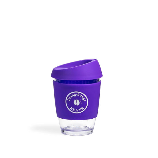 Clear glass reusable coffee keep cup with purple lid featuring a logo on a white background